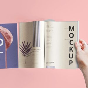 a hand holding a book open to a mockup